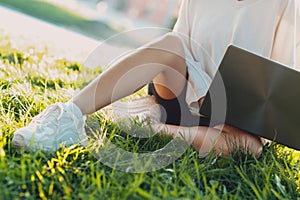 Millenial young woman blonde short hair outdoor smiling portrait with laptop.