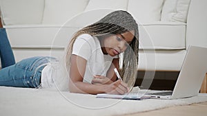 Millennial african ethnic woman student using laptop leaning at home, mixed race disciple distance education typing on