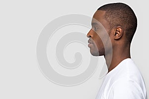 Millennial african man standing in profile isolated on white background
