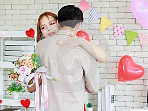 Millennial Asian beautiful female girlfriend standing smiling holding roses flower bouquet hugging cuddling showing love with