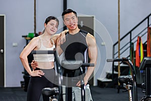 Millennial Asian fit strong muscular male and female fitness model athlete friend in sportswear standing posing with riding