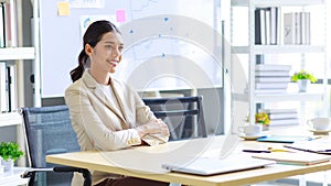 Millennial Asian happy cheerful pretty businesswoman secretary employee sitting smiling enjoy working online typing laptop