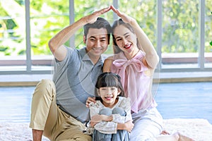 Millennial Asian happy family father mother and little girl daughter in casual outfit sitting laying lying down on fluffy carpet