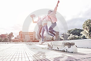 Millennial asian women jumping outdoor - Happy girls friends having fun in urban city park - Generation z, youth, young people