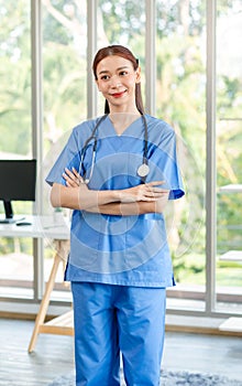 Millennial Asian young beautiful professional successful female internship nurse in blue clinical uniform with stethoscope