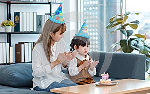 Millennial Asian young female teenager mother nanny babysitter wearing tall hat sitting together with little cute preschooler