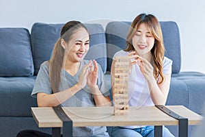 Millennial Asian young happy cheerful joyful female lesbian LGBTQ lover couple sitting smiling laughing together on carpet floor