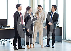 Millennial Asian young professional successful male female businessman businesswoman in formal suit standing smiling shaking hands