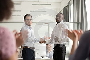 Millennial boss handshake black colleague congratulating with promotion