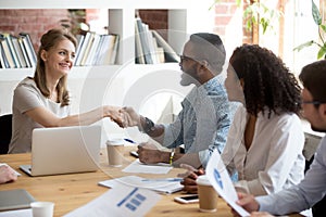 Millennial businesswoman handshake black employee greeting at me