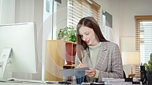 Millennial businesswoman holding digital tablet working with financial data at home office