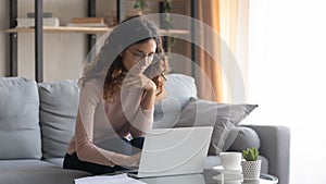 Young Caucasian woman in glasses work on laptop at home photo