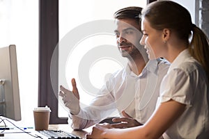 Colleagues negotiate looking at computer in office photo