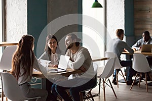 Millennial couple buying house meeting with realtor in cafe