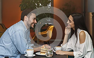 Millennial Couple In Love Talking Sitting In Coffee Shop photo
