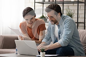 Millennial couple pay bills online on laptop