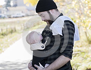 Millennial Dad with Baby in Carrier Outside Walking