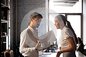 Diverse employees argue over financial report in office photo