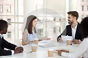 Millennial employees smiling negotiating at office briefing