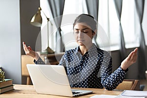 Millennial ethnic woman meditate at workplace at home