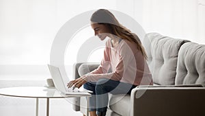 Millennial female freelancer using computer at home.