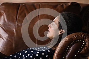 Millennial female patient lie on comfy couch at psychologist cabinet