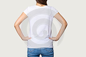 Millennial female wearing white t-shirt standing turning back to camera