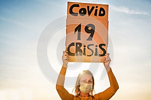 Millennial girl protest for Covid !9 economic crisis - Womand demonstrator wearing surgical mas for coronavirus prevention - Focus