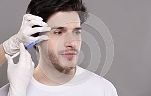 Millennial guy getting surgery filling of facial wrinkles