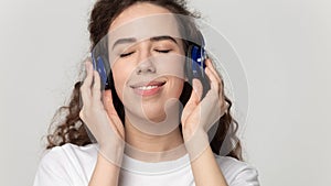 Millennial happy smiling lady wearing modern wireless headphones.