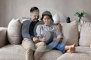 Millennial husband and wife using online application on tablet