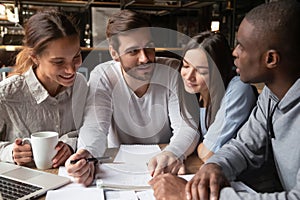 Multiracial young people studying in coffeehouse together photo