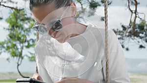 Millennial lady spending time outdoors with mobile gadgets