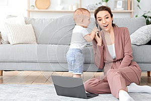 Millennial mom trying to work at home while baby distracting her