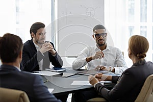 Multinational businessmen take part in group formal meeting in boardroom