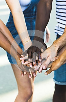 Millennial people celebrating together outdoor and stacking hands together -