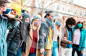 Millennial people group walking and having fun together wearing face mask at city center - New normal friendship concept with