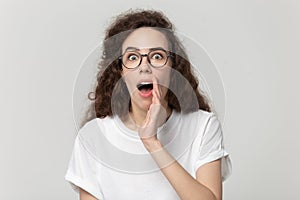 Millennial surprised curly girl sharing information or gossip.