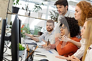 Millennial team working with new project on computer screen