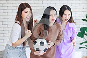 Millennial three Asian beautiful cheerful excited female girlfriends in casual outfit standing smiling holding football exciting