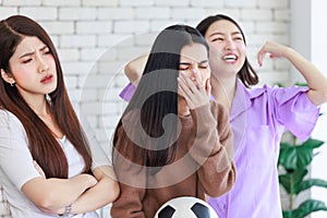 Millennial three Asian beautiful cheerful excited female girlfriends in casual outfit standing smiling holding football exciting