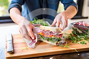 millennial unwrapping sandwich from reusable lunchbox