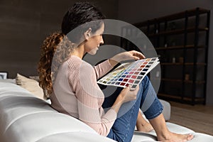 Millennial woman architect working from home think on colour swatch