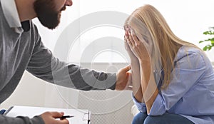 Millennial woman crying, therapist supporting her at personal meeting