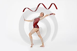 Millennial woman engaged in rhythmic gymnastics on white background