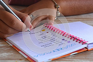 Millennial woman, writing in a bullet journal photo