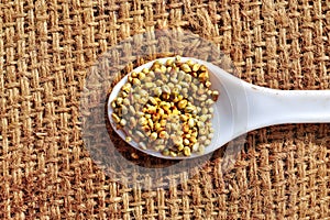 Millet on agriculture sack background,white spoon on  millets seeds, bajra grain agriculture sack background