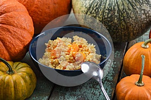 Millet porridge with sweet pumpkin in navy blue bowl decorated w