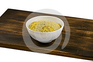 Millet in white bowl on brown board. Wheat. Healthy dietary groats background.