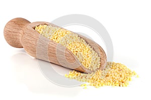 Millet in a wooden shovel isolated on white background